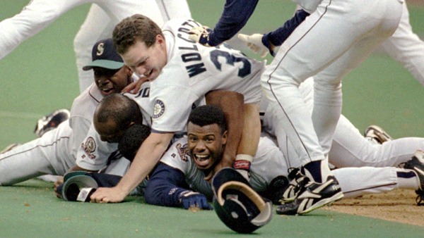 ADVANCE FOR WEEKEND EDITIONS JUNE 26-27--FILE--Seattle Mariners' Ken Griffey Jr. smiles from beneath a pile of teammates who mobbed him after he scored the winning run in the bottom of the 11th inning against the New York Yankees in this Oct. 8, 1995 photo in Seattle. The Mariners won 6-5. A lot of people won't be sad to see the Mariners leave Seattle's domed stadium and move across the street to the new $517 million Safeco Field. Seattle has had a love-hate relationship with the Kingdome.(AP Photo/Elaine Thompson)